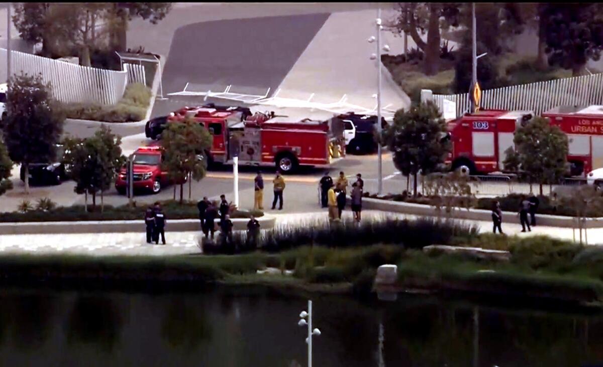 Firefighters search the artificial lake outside SoFi Stadium after receiving reports of a body in the water.