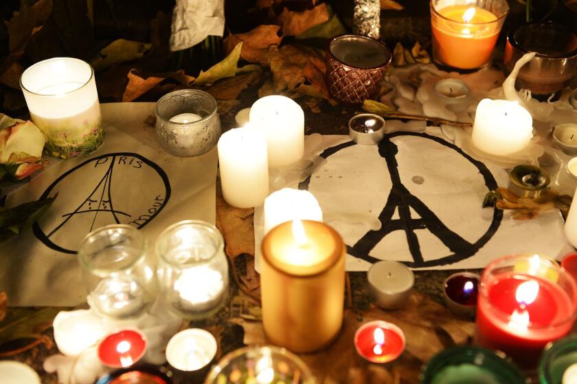 Candles and messages are left at a makeshift memorial next to the Bataclan concert hall in Paris.