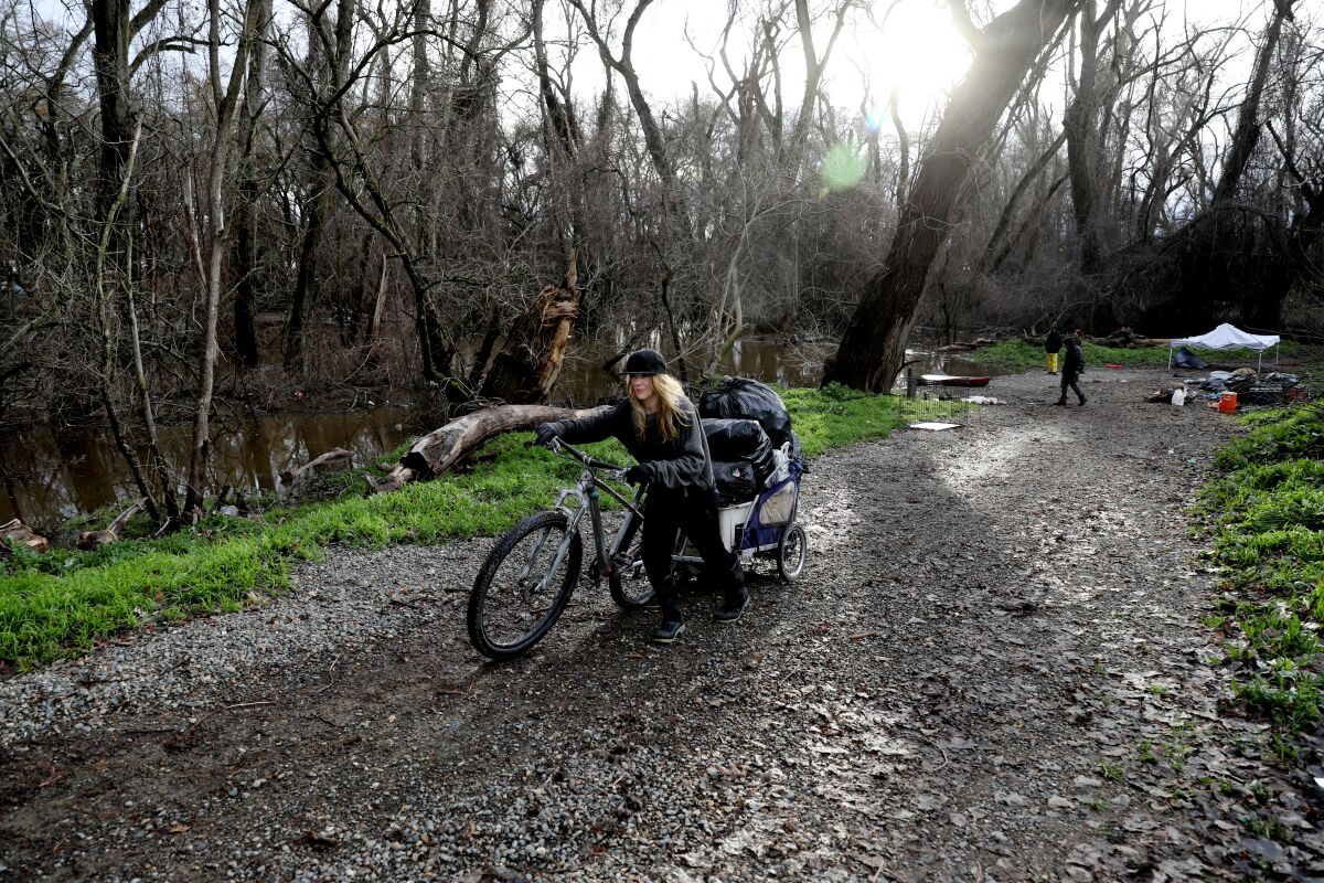 Laura Nussbaum moves her belongings to higher ground from a homeless encampment on Bannon Island