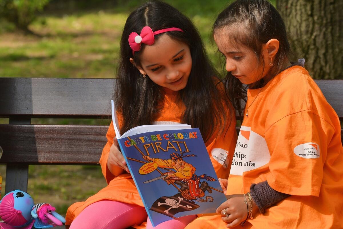 Children share a book on World Book Night (and Day) in Bucharest, Romania.