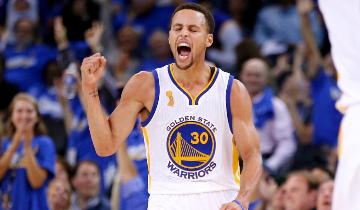 Golden State's Stephen Curry celebrates after making a three-point basket against the New Orleans Pelicans during the NBA season opener on Tuesday.