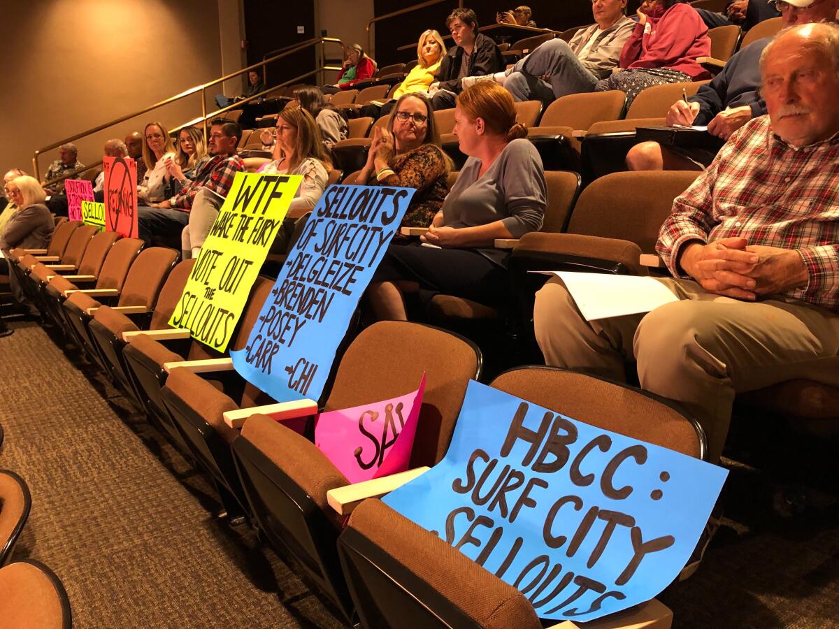 Signs displayed by protesters at Monday's Huntington Beach City Council meeting express opposition to recent advancements on the Magnolia Tank Farm redevelopment project and call council members "sellouts" for their appointed planning commissioners' recent decisions in the matter.