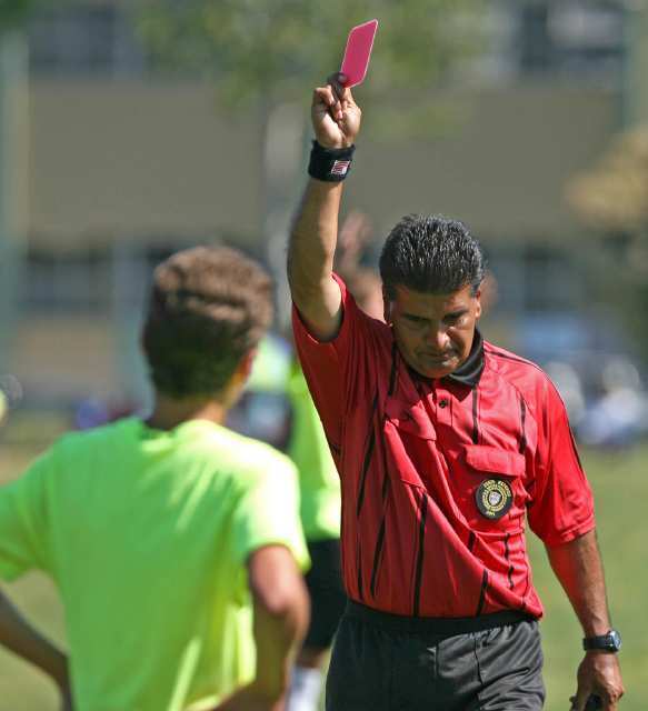 Head referee hands out a red card to Mariners Travis Campos after illegal spike first tackle in second half.