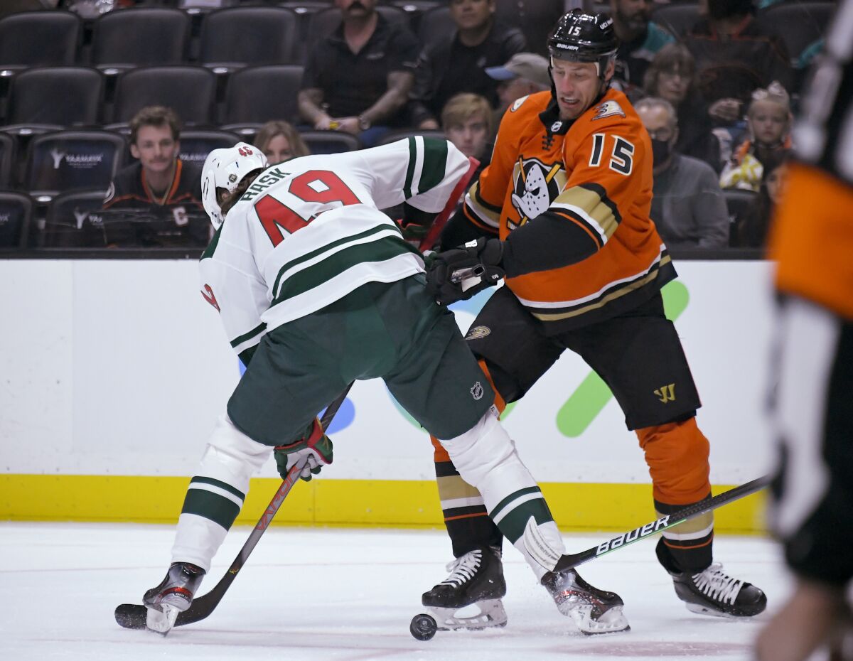 The Ducks' Ryan Getzlaf, right, battles the Wild's Victor Rask for the puck during the first period.
