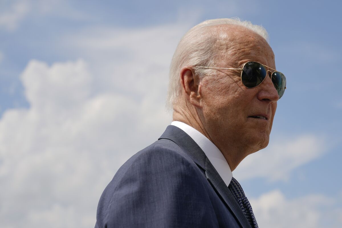 President Biden outdoors in front of a white cloud-filled sky