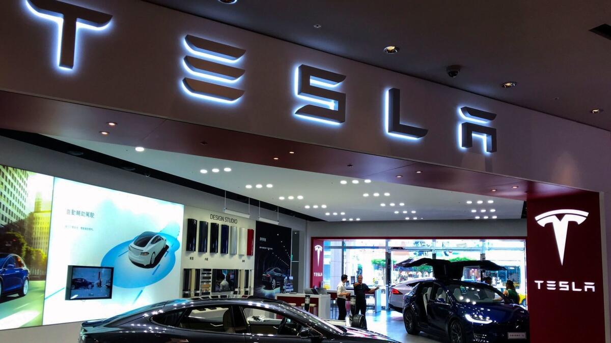 People look at Tesla cars at a showroom in Taiwan.