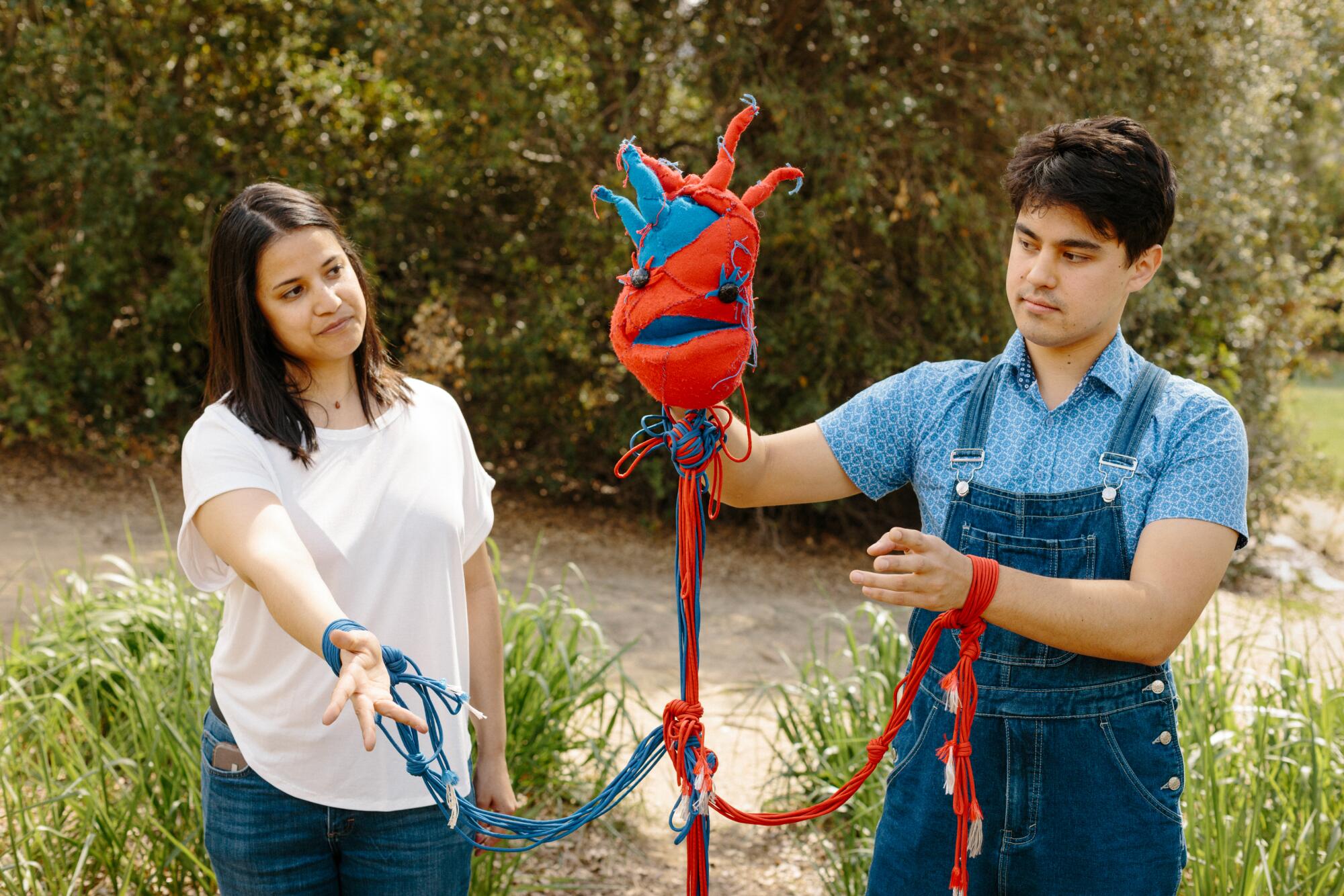 A woman and a man display a puppet.
