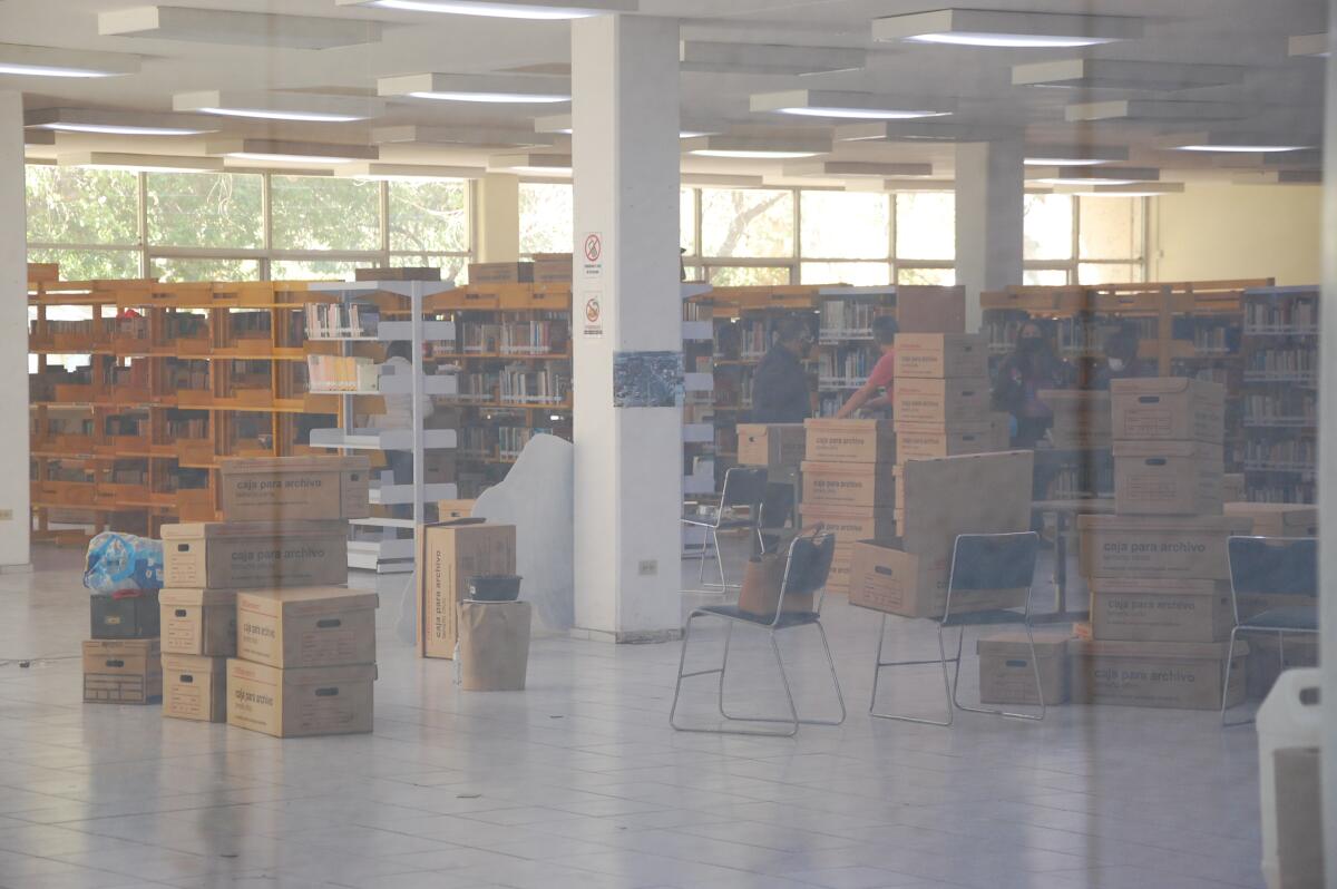 Employees of the Benito Juárez library are seen packing books to vacate the premises. 