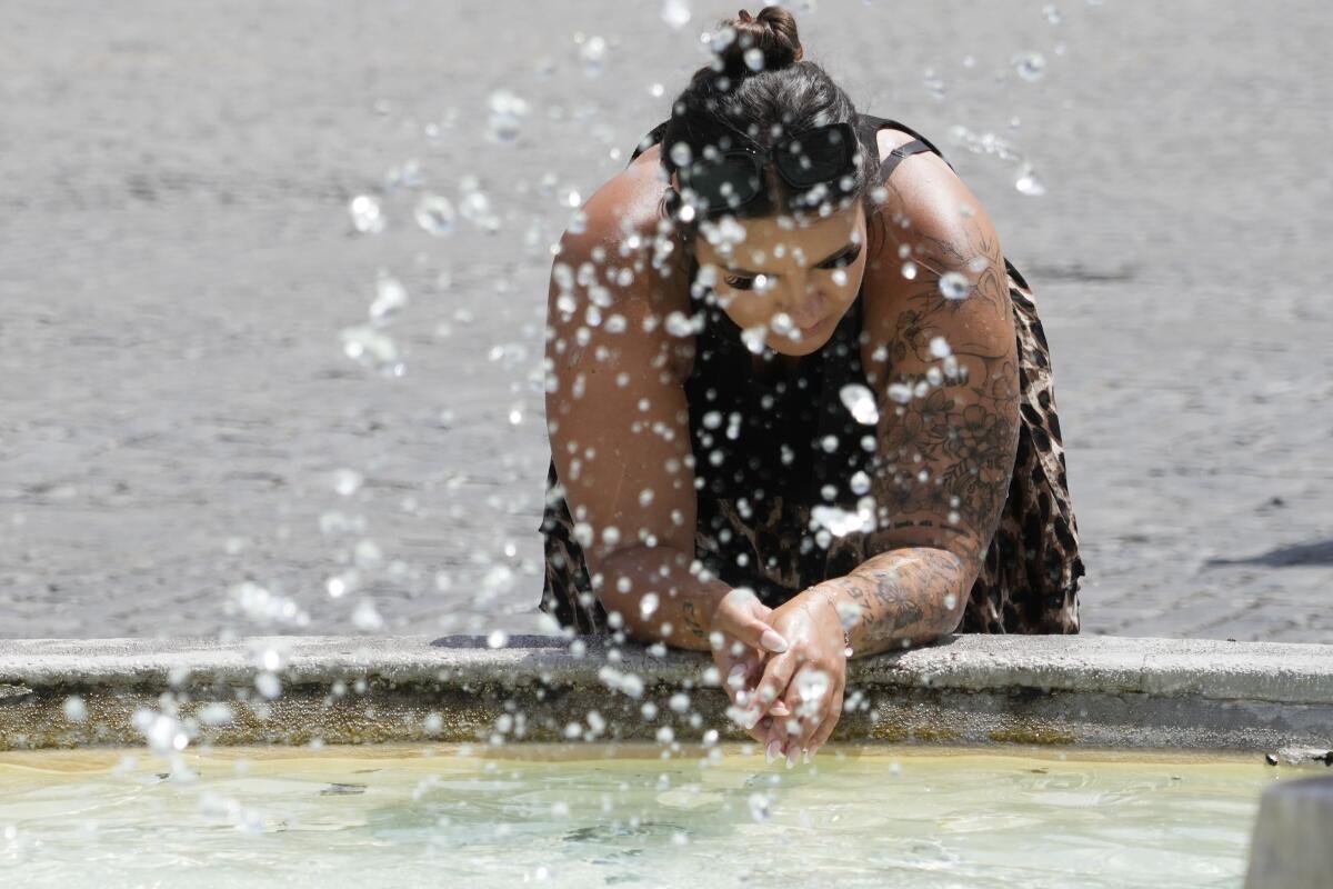 Woman cooling herself off at a fountain in Rome