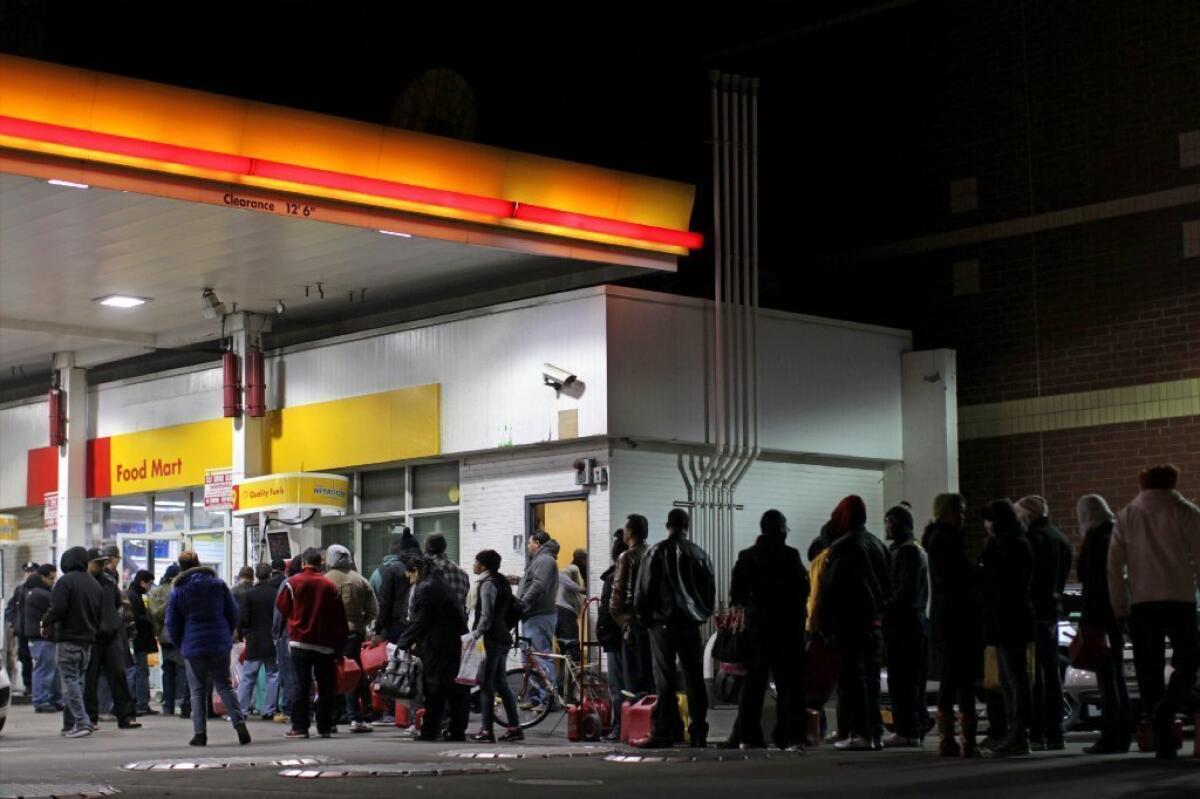 Police organize a line of New Yorkers hoping to buy fuel after Hurricane Sandy shut down some refineries in the region. Americans will spend a record $483 billion on gasoline in 2012, the Oil Price Information Service says.