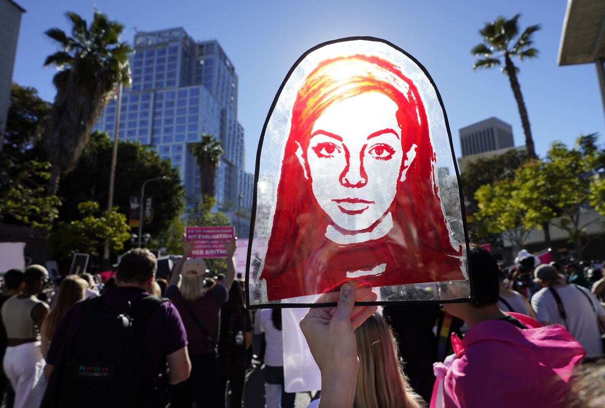 A Rubylith printing screen featuring a portrait of Britney Spears is held by Spears supporter Taylor Coppage outside a hearing concerning the pop singer's conservatorship at the Stanley Mosk Courthouse, Friday, Nov. 12, 2021, in Los Angeles. A Los Angeles judge ended the conservatorship that has controlled Spears' life and money for nearly 14 years. (AP Photo/Chris Pizzello)