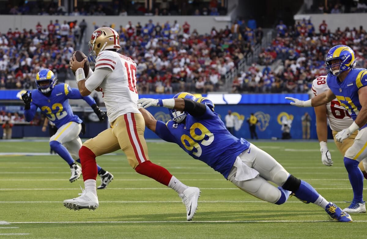 The Rams' Aaron Donald (99) reaches for the sack on 49ers quarterback Jimmy Garoppolo (10) in 2022.