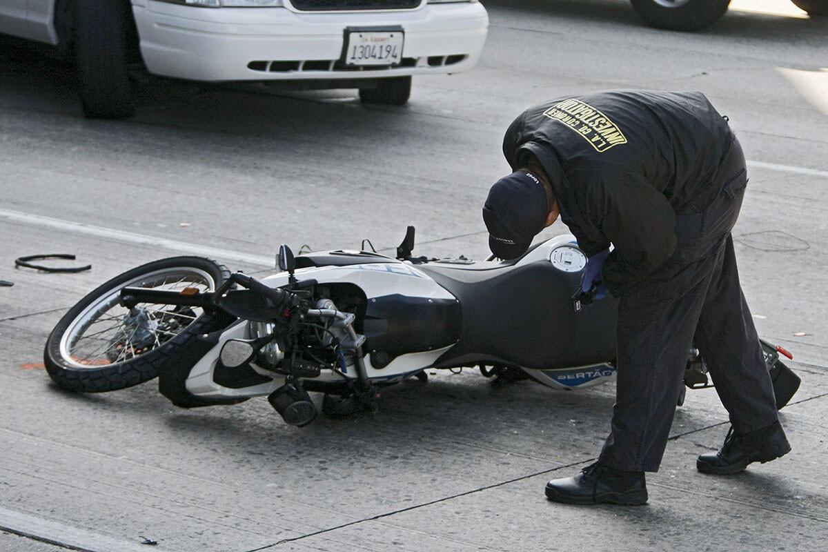A Los Angeles County Coroner Investigator examines the scene of a fatal motorcycle crash on the northbound 5 Freeway under the 134 Freeway overpass in the Glendale-Burbank area on Tuesday morning, Sept. 17, 2013. Traffic was backed up for miles on the 134 and 5 freeways.