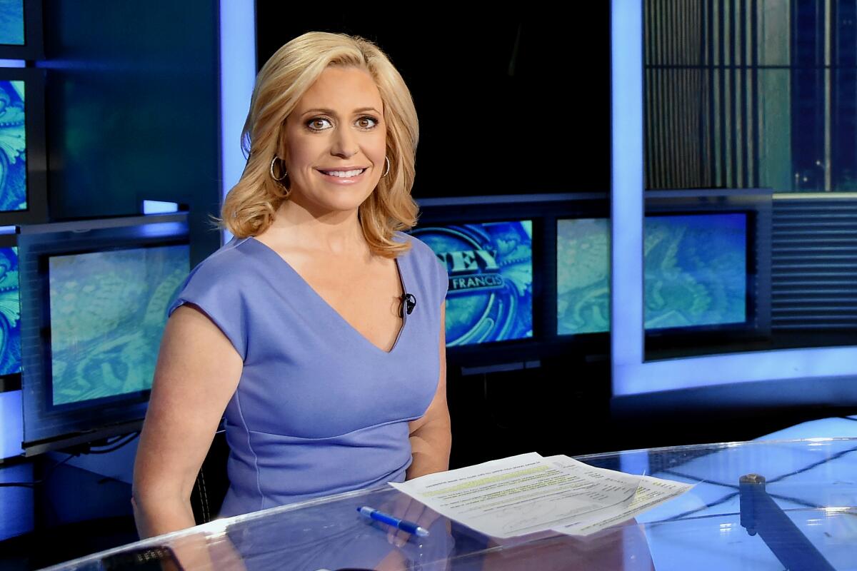Television journalist Melissa Francis sits at a desk.