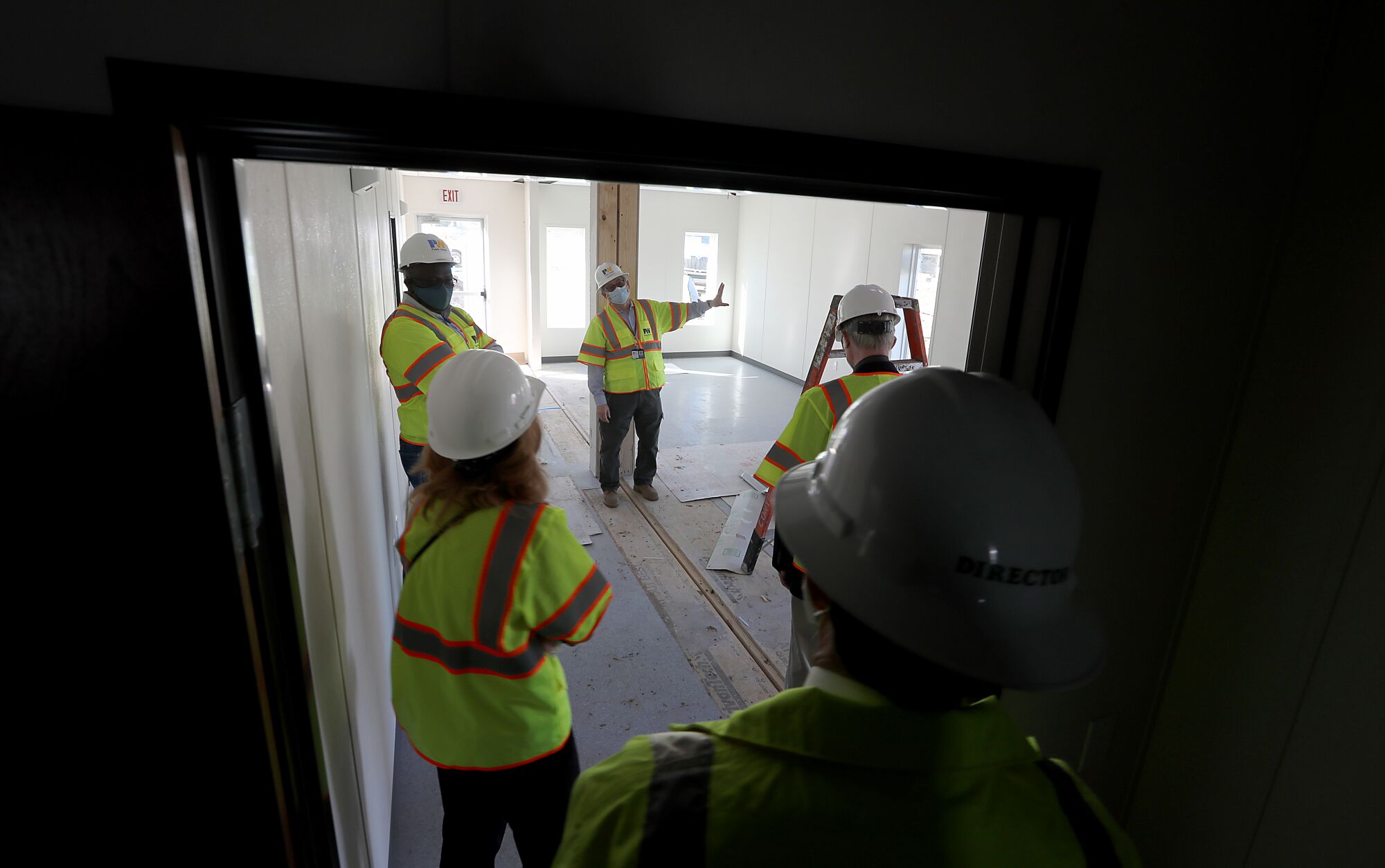  L.A. County officials and contractors tour the site of a homeless housing project.