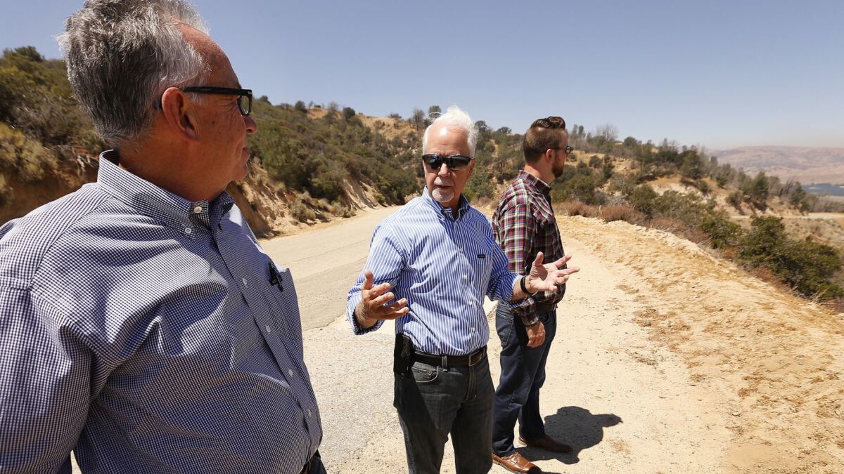 Barry Zoeller, center, vice president of corporate communications for Tejon Ranch Co., stands on a bluff overlooking the Centennial site on Tejon Ranch with Greg Medeiros, left, and Nathan Keith, right, Aug. 6.