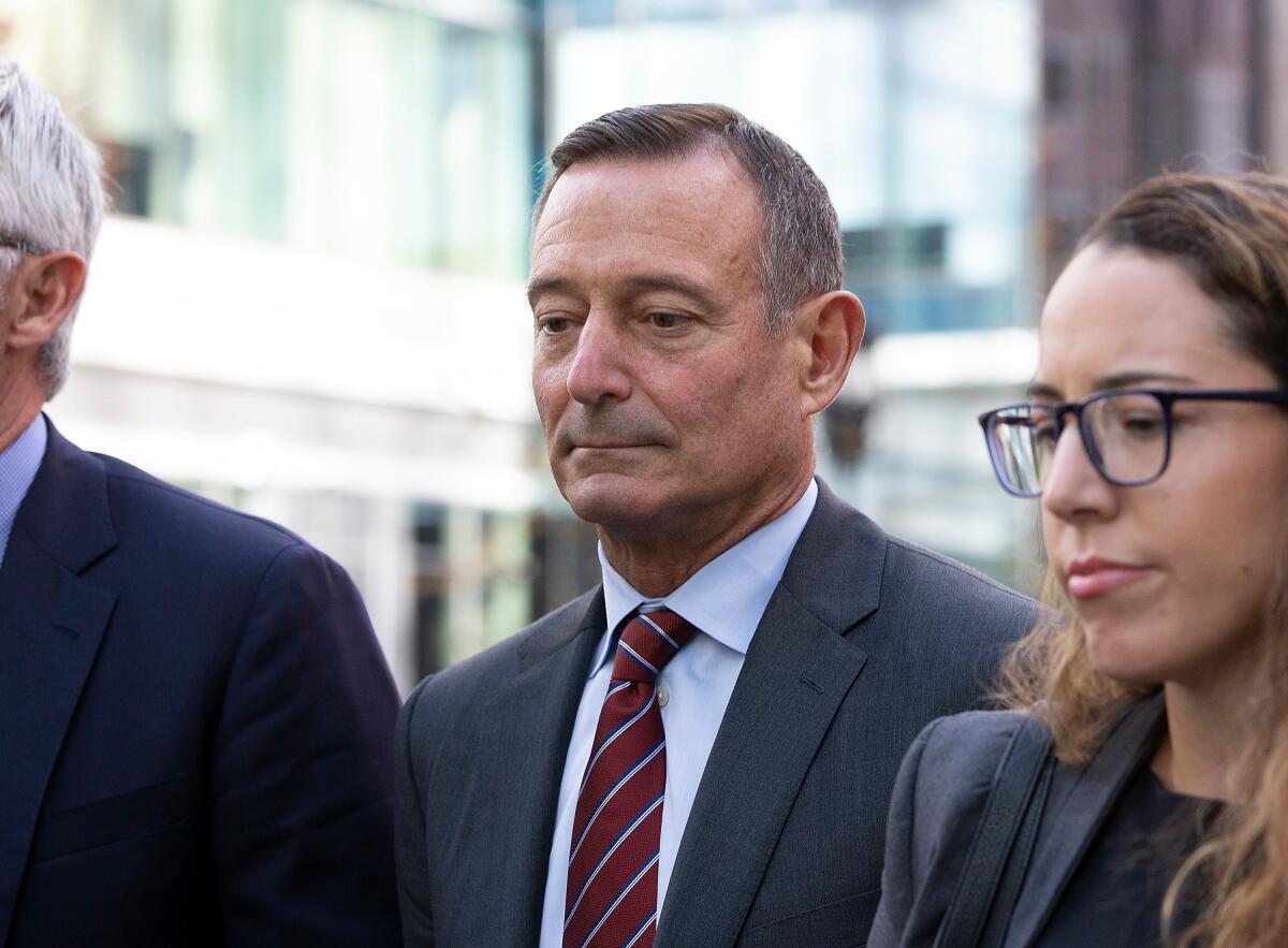 Former PIMCO Chief Executive Douglas Hodge leaves the federal courthouse in Boston with his attorneys in October after pleading guilty to paying to get four of his children into USC and Georgetown University as fake athletic recruits.