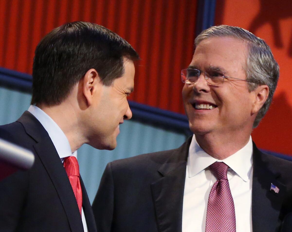 Republican presidential candidates Marco Rubio and Jeb Bush talk during a break at this year's first Republican presidential debate in Cleveland.