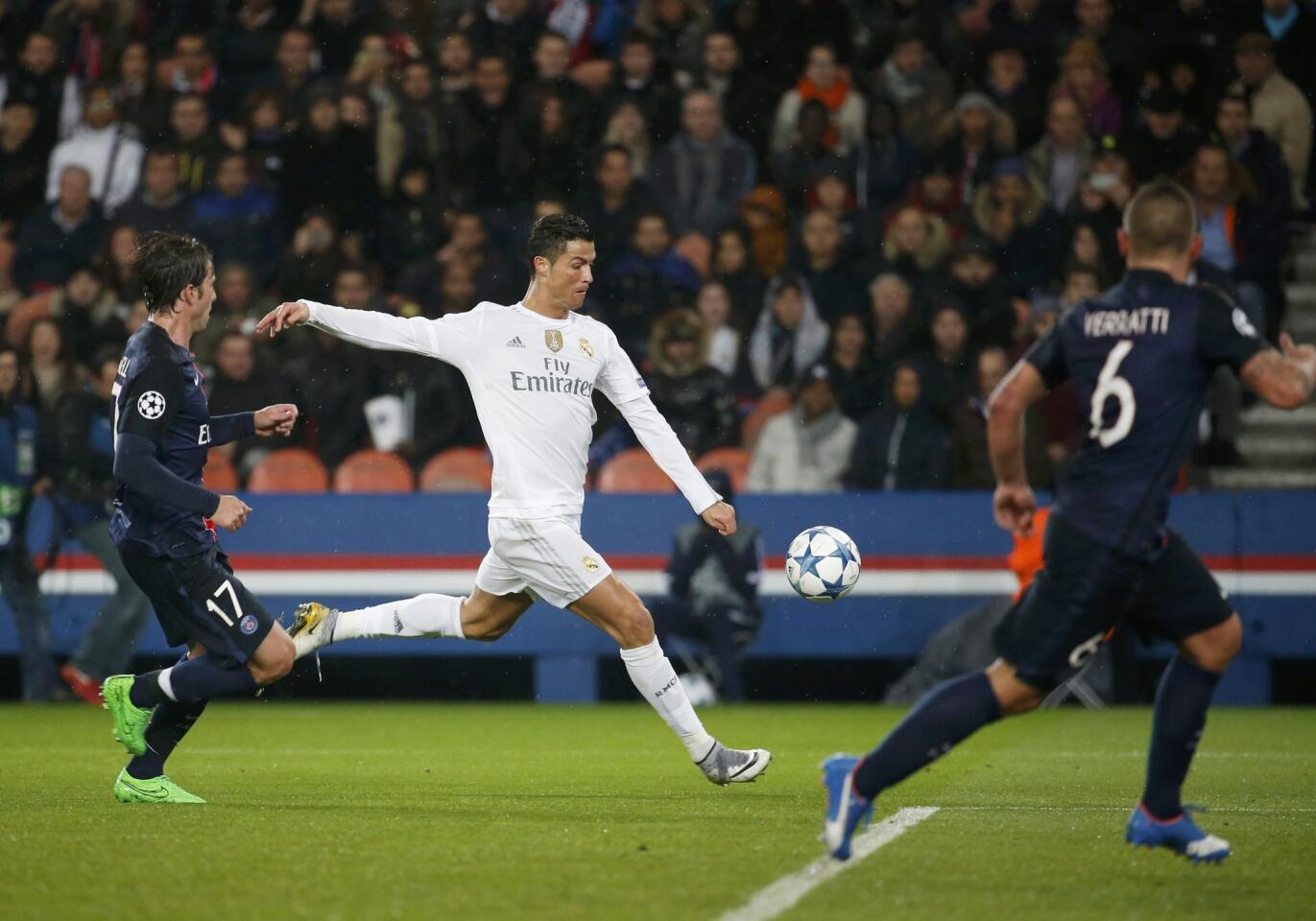 Real Madrid's Cristiano Ronaldo challenges Paris Saint Germain's Maxwell and Marco Verratti during their Champions League Group A soccer match at the Parc des Princes stadium in Paris