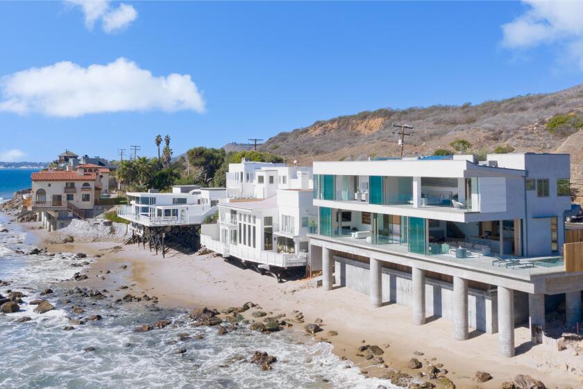 Built in 2021, the two-story home overlooks the ocean from a patio with a pool and a rooftop deck with a hot tub.