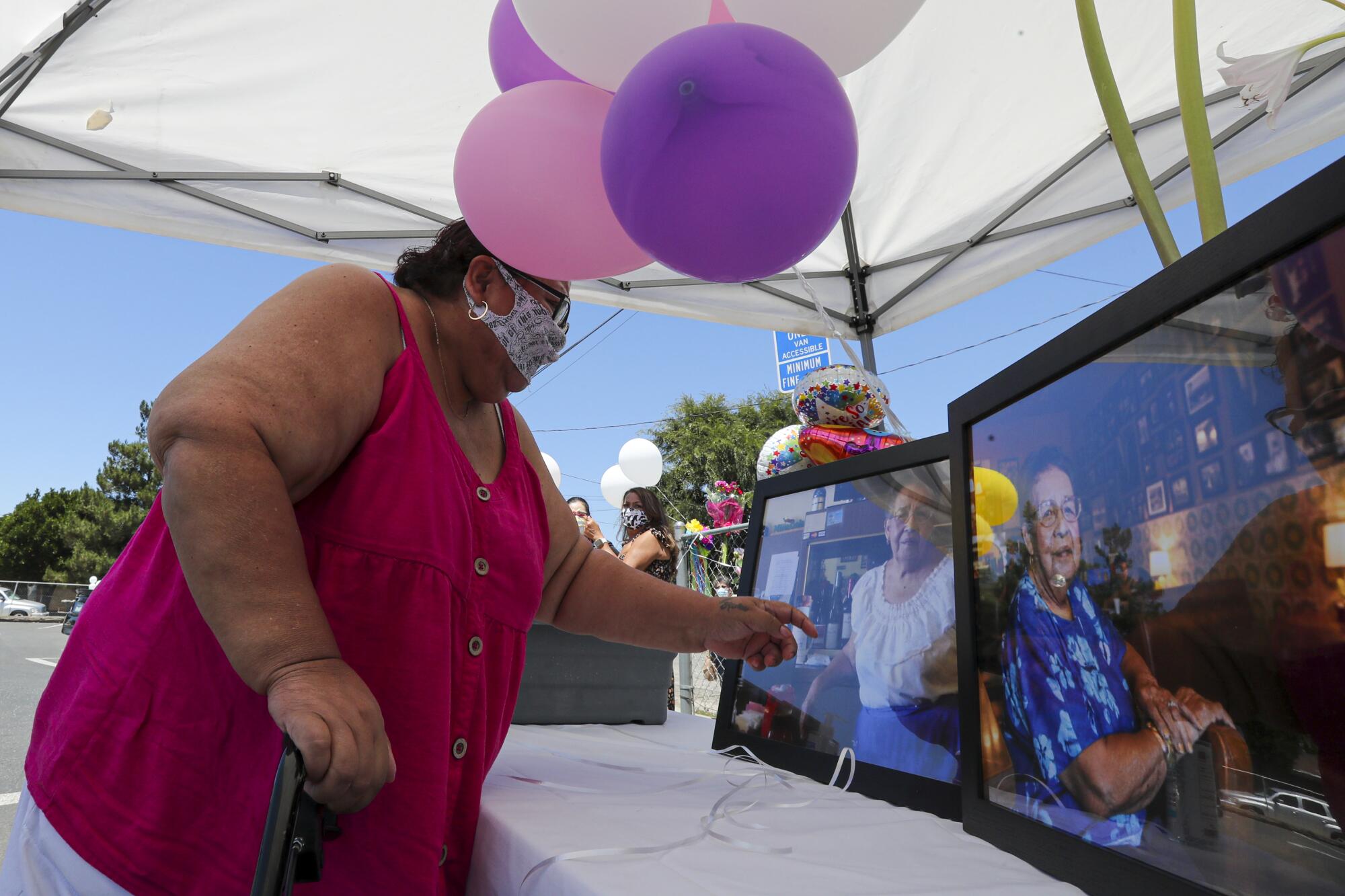 Ricarda Reyes touches a photo of her mother, Lucy Reyes, at the memorial service