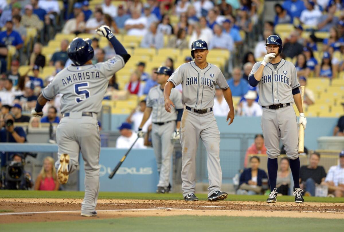 San Diego Padres' Alexi Amarista, left, points to the sky as he heads home after hitting a two-run home run as teammates Will Venable, center, and Jesse Hahn stand near during the second inning against the Dodgers on July 11, 2014.