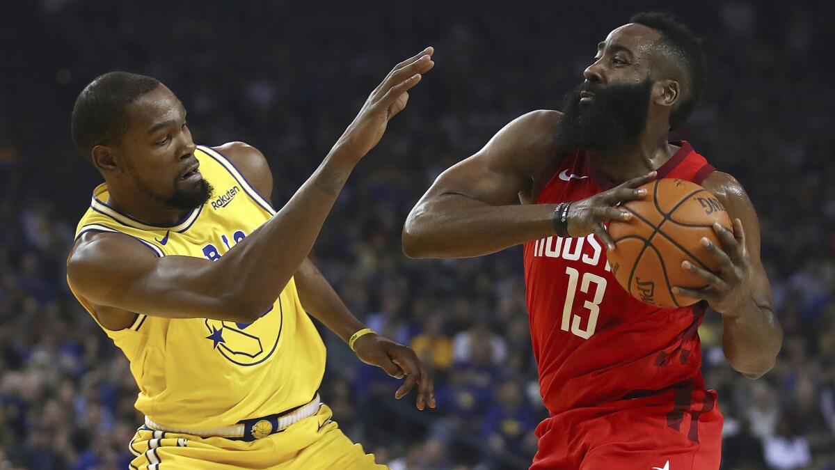 Golden State Warriors' Kevin Durant, left, defends against Houston Rockets' James Harden during the first half.