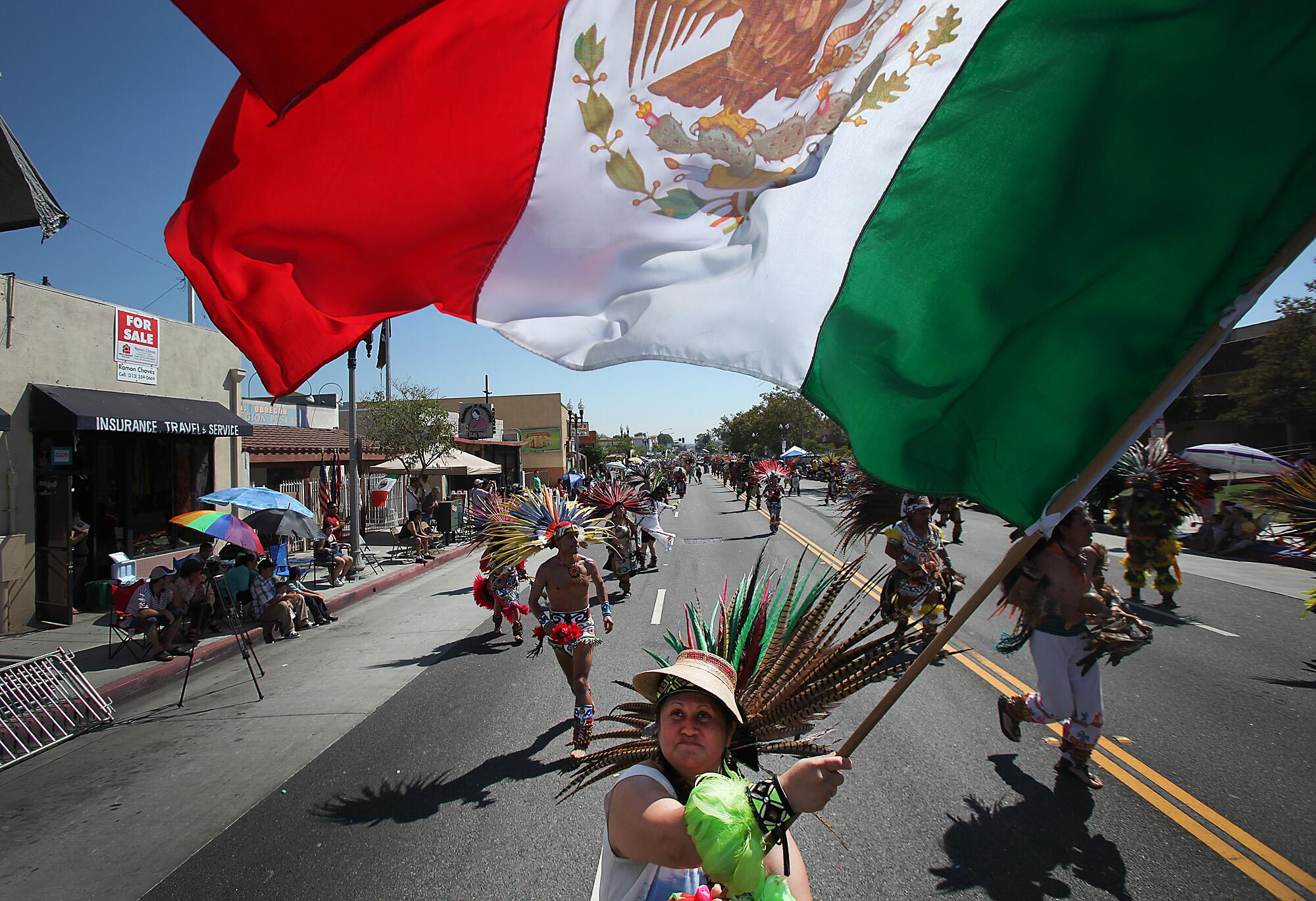 A woman marches with a Mexican flag