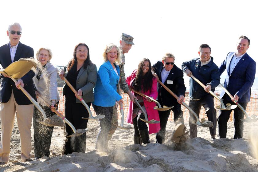 Huntington Beach Mayor Gracey Van Der Mark, center, poses with local dignitaries as they shovel sand for the groundbreaking ceremony for the Surfside-Sunset Beach sand replenishment project in Seal Beach on Wednesday, December 13, 2023. (Photo by James Carbone)