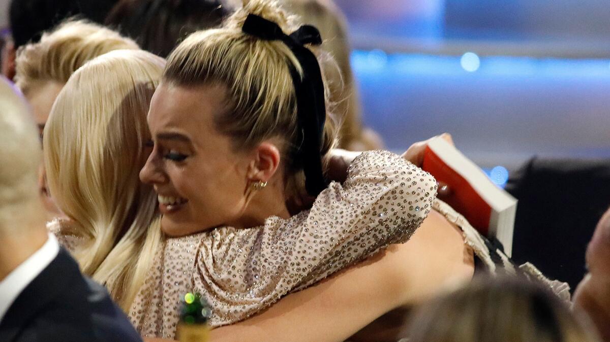 Margot Robbie shares a hug with fellow nominee Saoirse Ronan after Robbie won the 2018 Critics' Choice Award for best actress in a comedy for her performance in, "I, Tonya."