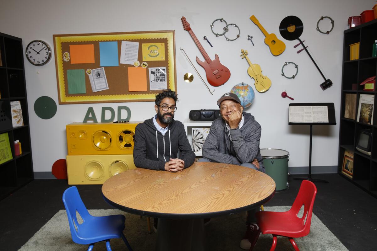 Hip-hop mogul Russell Simmons, right, and Sanjay Sharma, president and CEO of Simmons' new company, All Def Digital, on the set of their original show "Arts+Raps" in the company's downtown Los Angeles office.