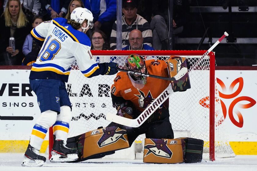 Arizona Coyotes goaltender Karel Vejmelka, right, makes a save on a shot by St. Louis Blues center Robert Thomas (18) during the first period of an NHL hockey game in Tempe, Ariz., Thursday, Jan. 26, 2023. (AP Photo/Ross D. Franklin)
