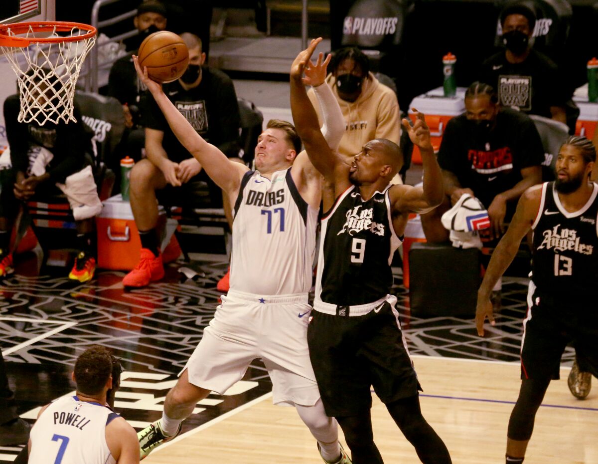 The Mavericks' Luka Doncic is fouled by the Clippers' Serge Ibaka in the fourth quarter May 22, 2021.