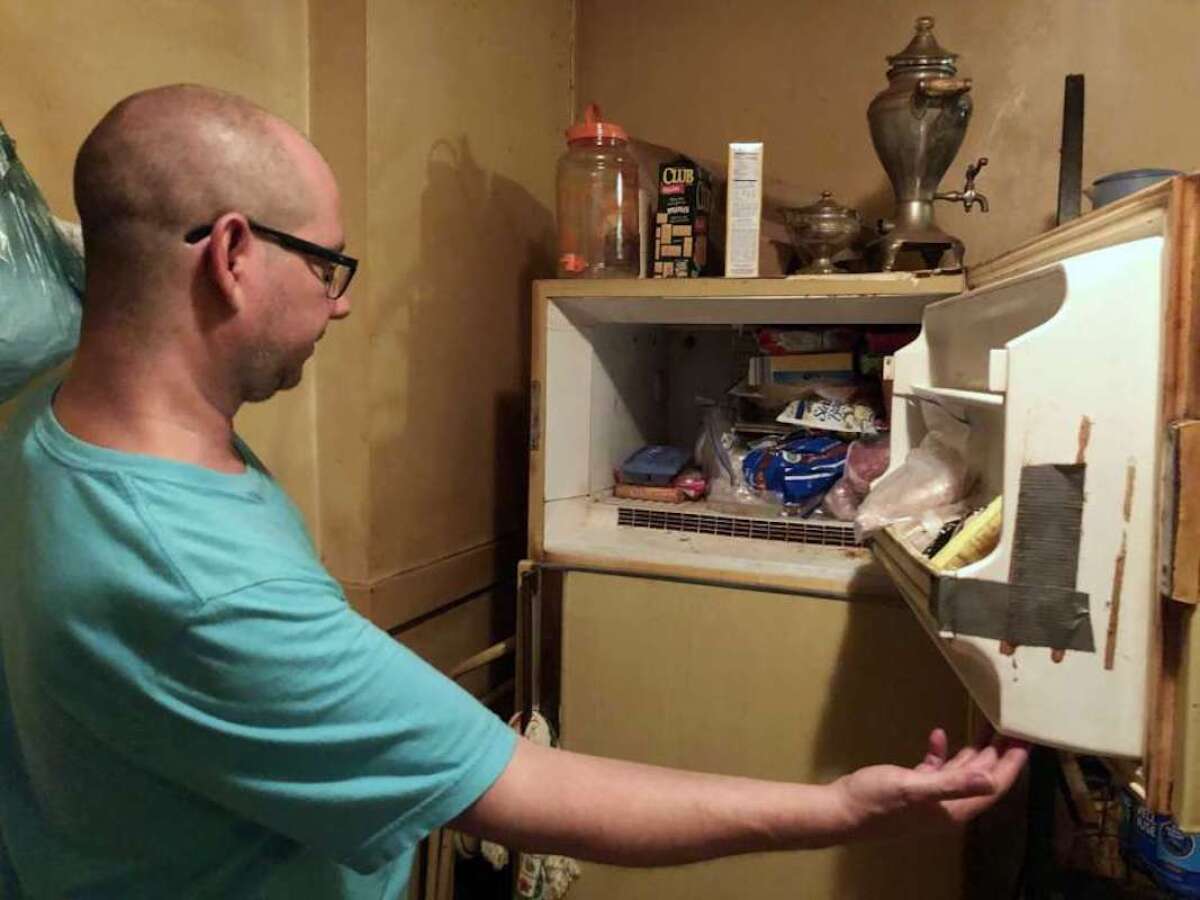 Adam Smith se asoma al congelador de su madre en St. Louis, donde dice que encontró los restos de un bebé en una caja y que ella mantuvo allí durante más de 40 años. La madre falleció el 21 de julio, a la edad de 68 años, por cáncer de pulmón.