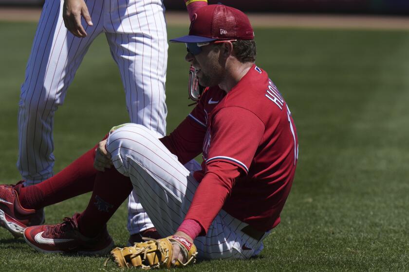 FILE - Philadelphia Phillies first baseman Rhys Hoskins clutches his knee after getting injured against the Detroit Tigers during the second inning of a spring training baseball game March 23, 2023, in Clearwater, Fla. Hoskins remained a longshot to make the postseason roster as he recovers from a torn ACL in his left knee. Phillies manager Rob Thomson said Tuesday, Sept. 26, that the slugger still is not likely to get cleared ahead of the World Series, if it all. (AP Photo/Chris O'Meara, File)