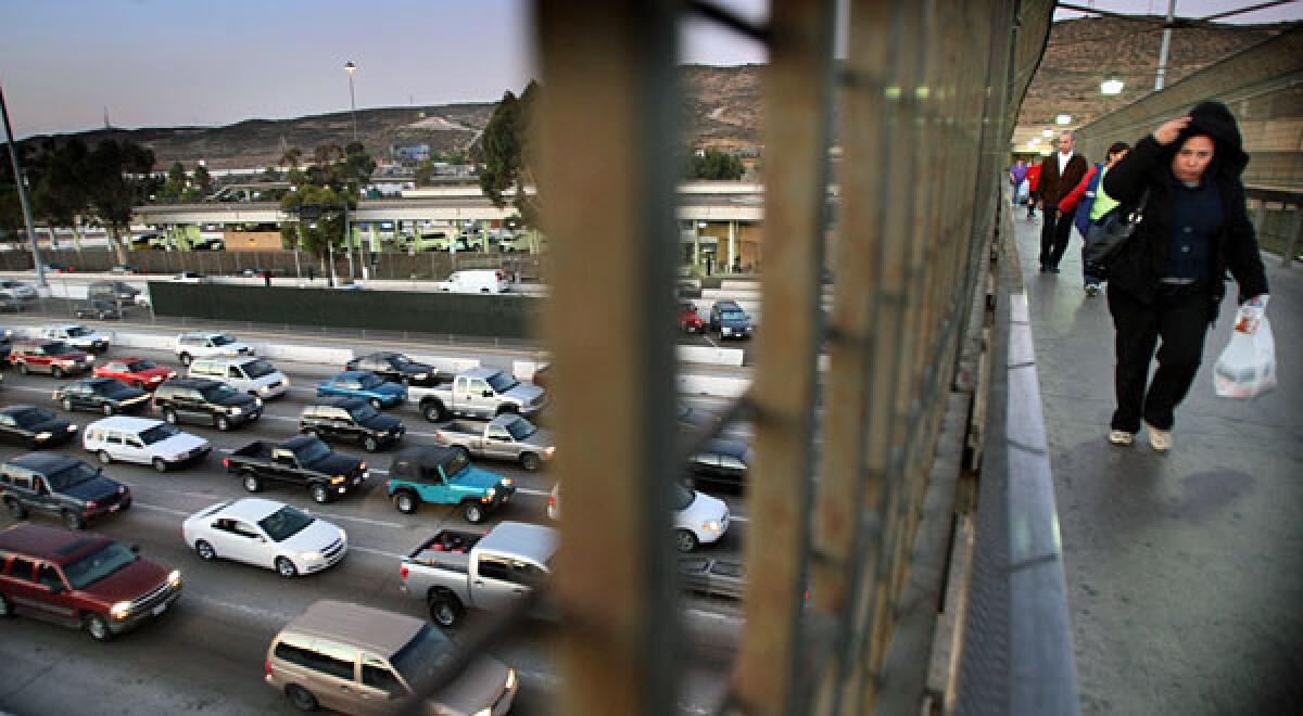 Traffic on I¿5 approaching the San Ysidro/Tijuana border gate clogs all southbound lanes. Shoppers and workers walk on an overpass leading to the pedestrian gate to Mexico.