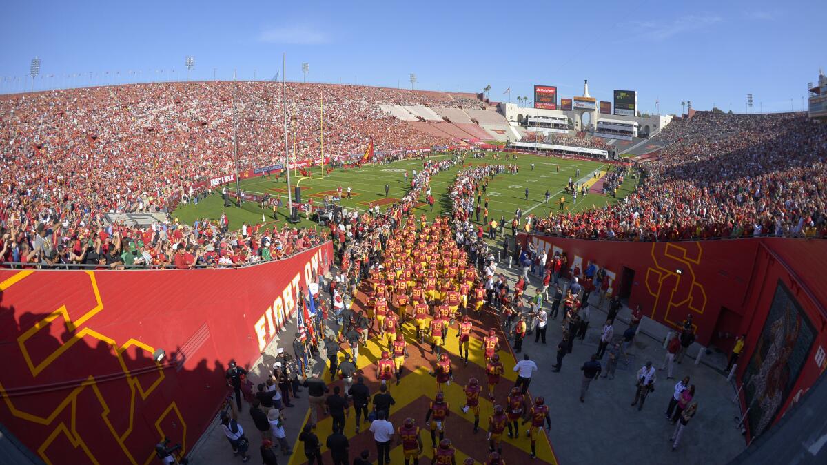 USC players run onto the field at the Coliseum before their win over Notre Dame on Saturday.