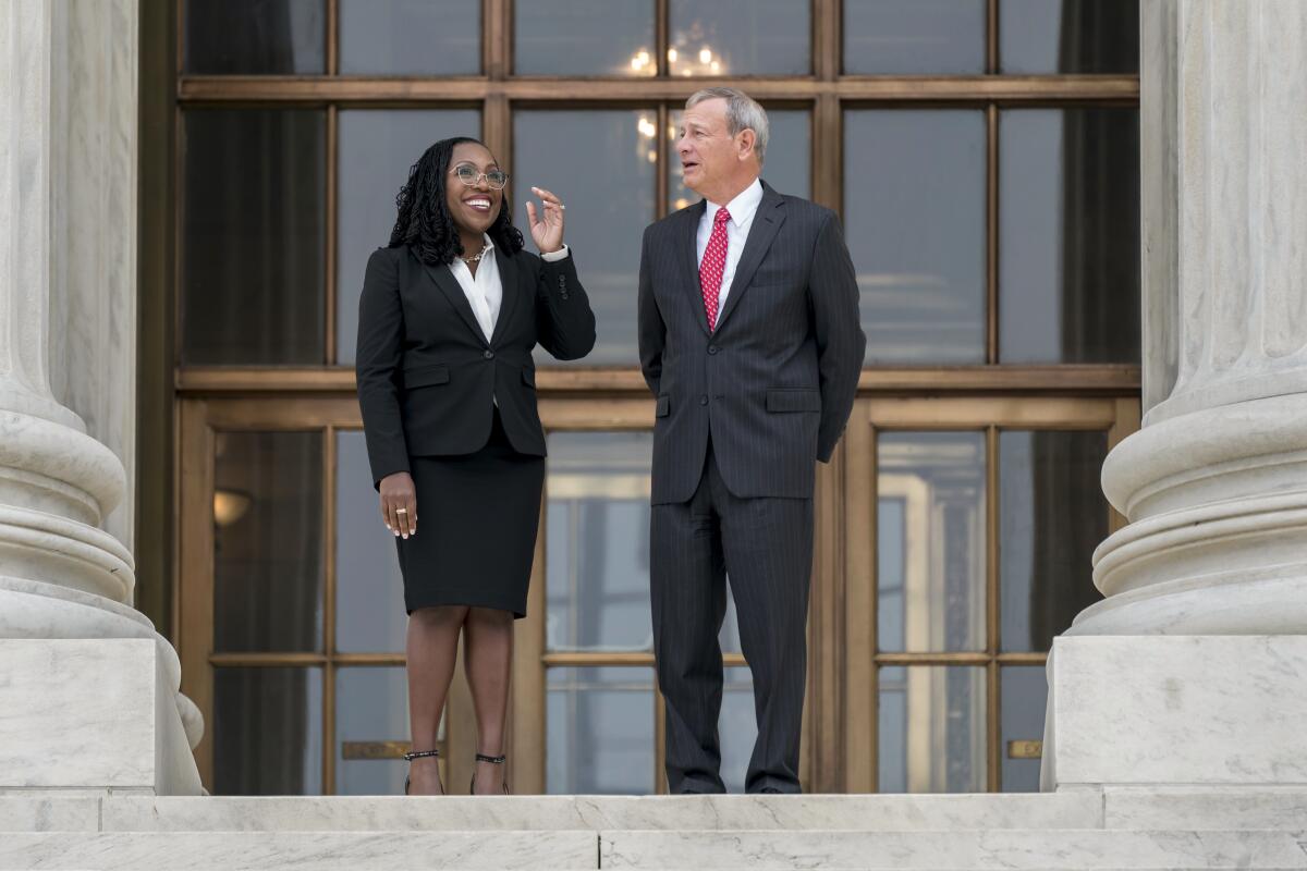 Justice Ketanji Brown Jackson and Chief Justice John G. Roberts Jr. talking as they stand outside the Supreme Court.