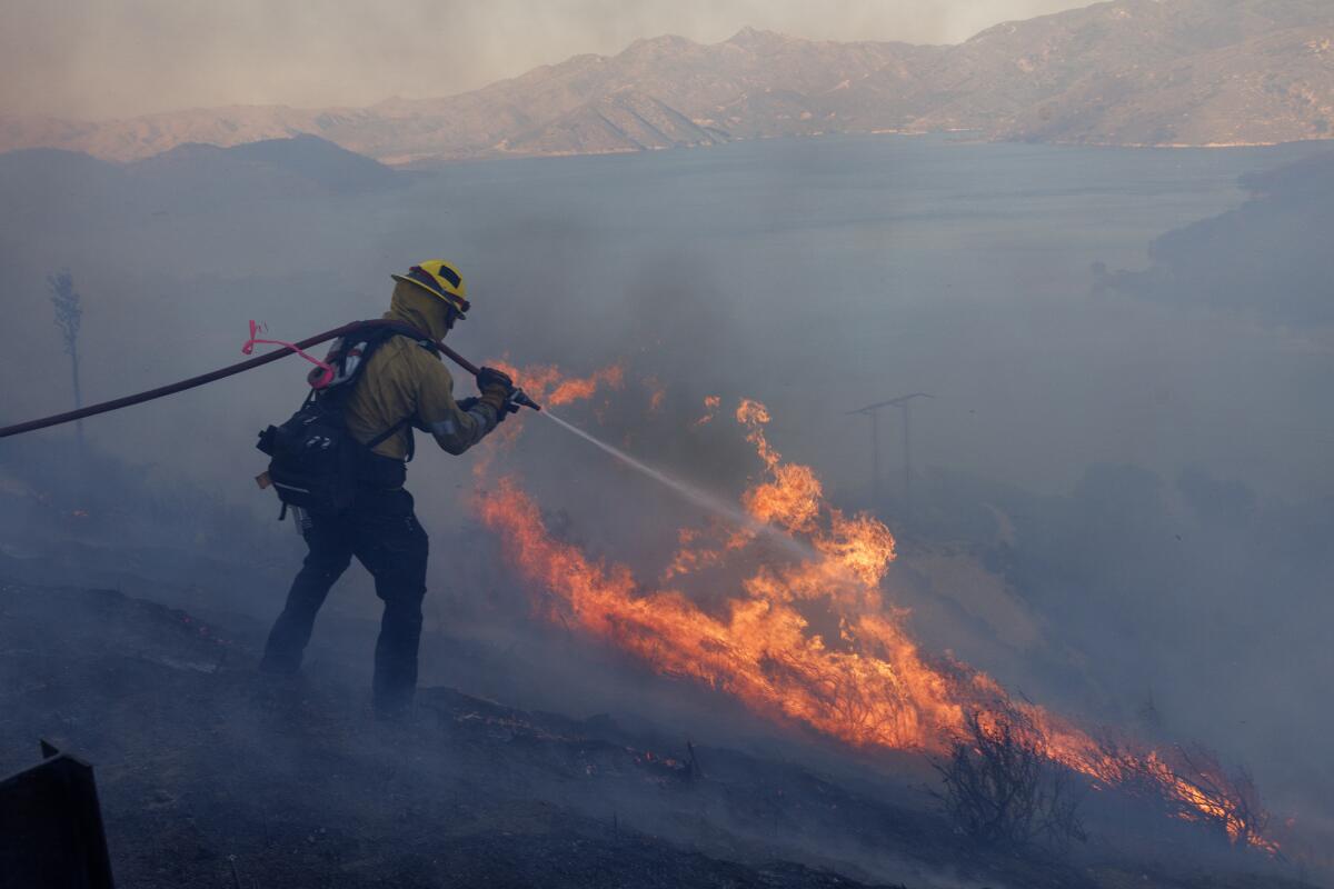 A firefighter spraying water on flames