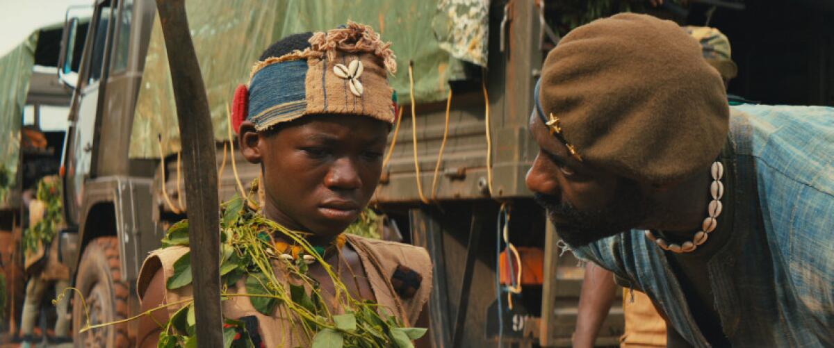 Abraham Attah, izquierda, como Agu, e Idris Elba, como el comandante en la película de Netflix "Beasts of No Nation" de Cary Fukunaga.