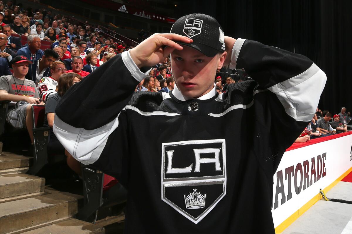 Jaret Anderson-Dolan puts on a Kings hat after being selected 41st overall by the team in the 2017 NFL Draft.