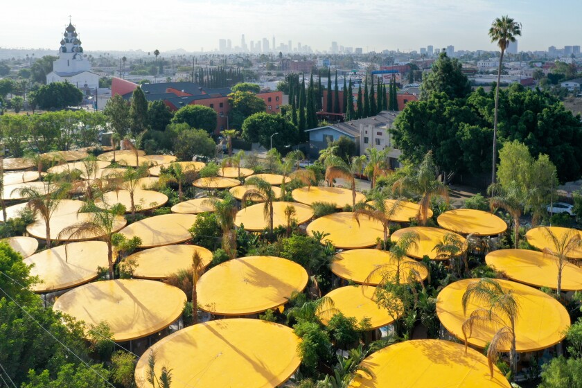 An overhead view of the Second Home garden coworking studios shows a series of elliptical yellow roofs surrounded by plants