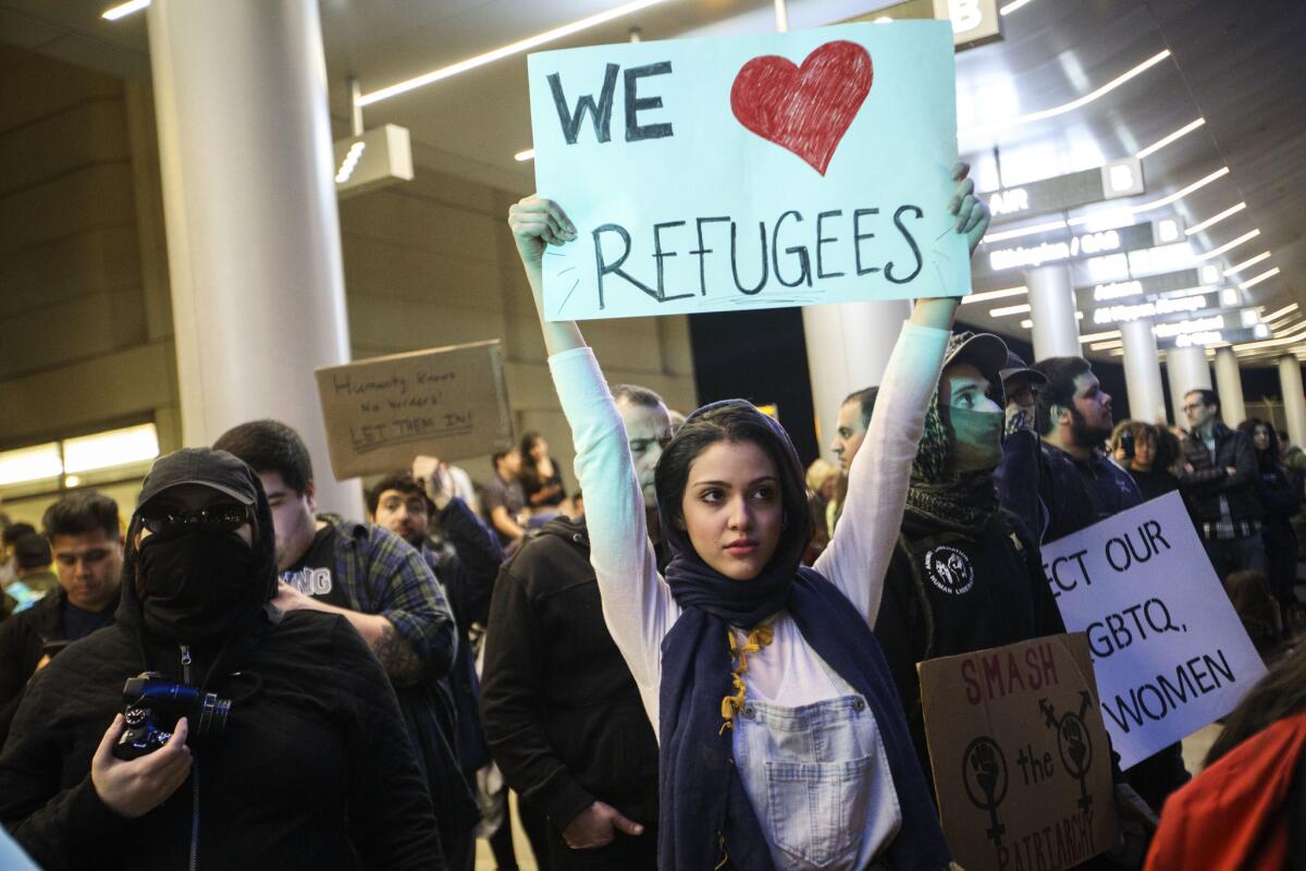 Protesters against President Trump's refugee plan gathered Sunday night at Los Angeles International Airport.