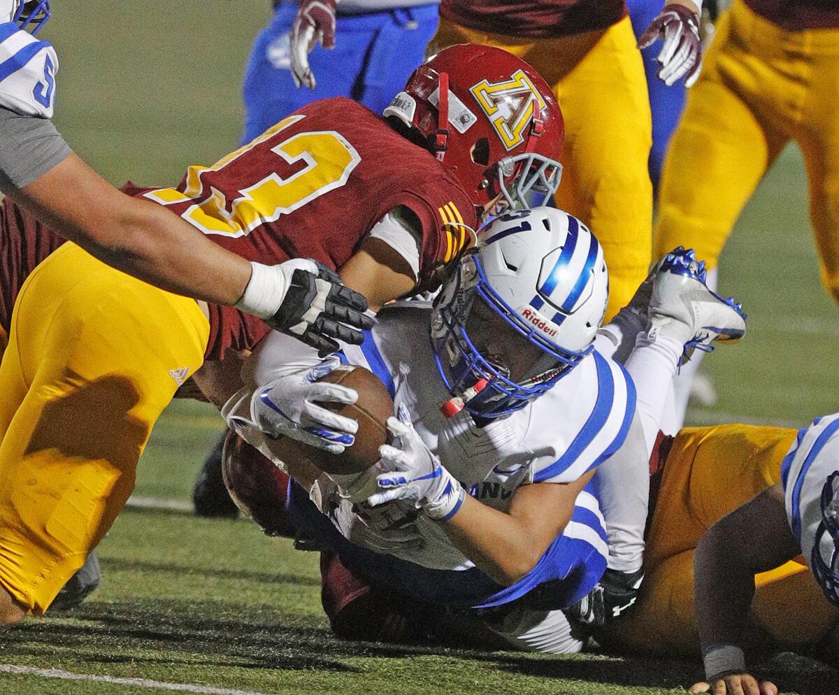 Burbank's Tyler Murphy reaches and nearly scores before Arcadia's Will Covey holds him out of the end zone in a Pacific League football opener at Arcadia High School on Thursday, September 19, 2019.