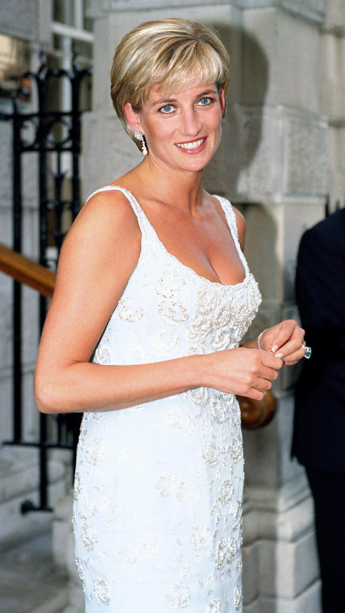June 1997 — Diana wears a tank dress by Catherine Walker to an auction at Christie’s.
