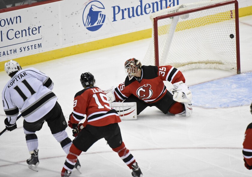 Kings forward Anze Kopitar scores a goal past Devils goalie Cory Schneider (35) while Travis Zajac (19) looks on during the third period.
