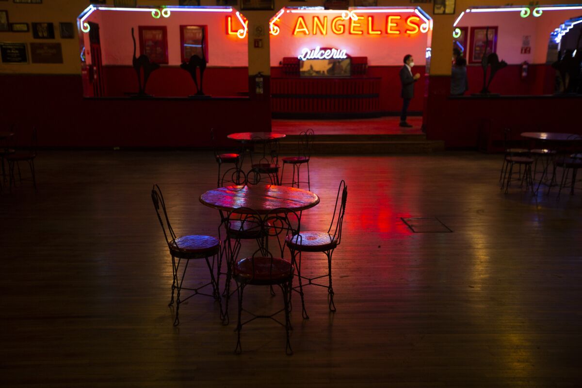 Tables and chairs sit the empty Salon Los Angeles during an event to raise money and keep open the iconic dance hall known as “The Cathedral of Mambo” amid the new coronavirus pandemic in Mexico City, Saturday, Sept. 5, 2020. Millionaires, writers, ambassadors, and movie stars danced here; now, shuttered for more than five months due to the pandemic, the owners of the fabled hall say they are in debt and may have to close and demolish it. (AP Photo/Fernando Llano)