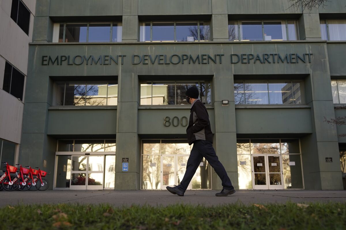 FILE - In this Dec. 18, 2020, file photo, a person passes the office of the California Employment Development Department in Sacramento, Calif. The recession that broke out with onset of the coronavirus pandemic officially ended in April 2021, making it the shortest downturn on record, according to the committee of economists that determines when recessions begin and end. (AP Photo/Rich Pedroncelli, File)