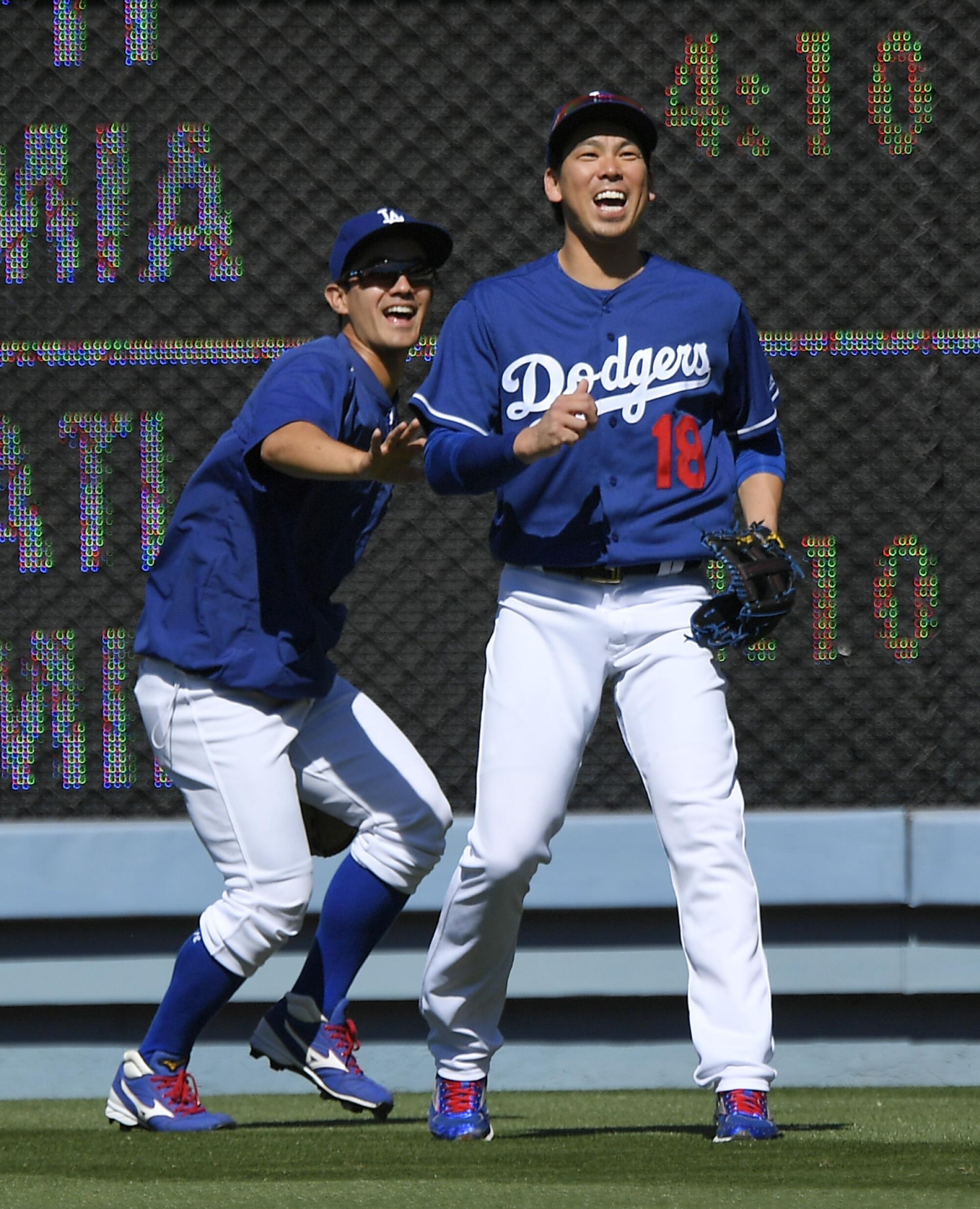 Kenta Maeda, right, catches fly balls with interpreter Will Ireton. during batting practice.