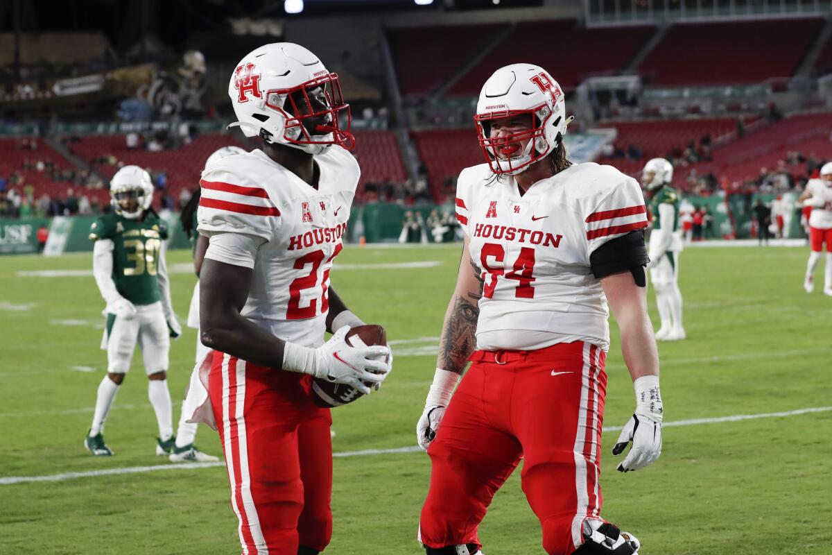 Houston running back Alton McCaskill, left, celebrates with Dennis Bardwell after scoring against South Florida during the second half of an NCAA college football game Saturday, Nov. 6, 2021, in Tampa, Fla. (AP Photo/Scott Audette)